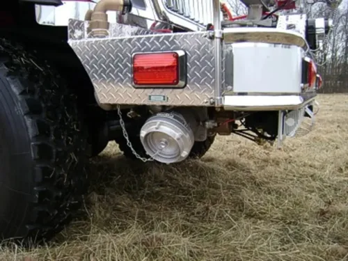 Exterior view of small fire truck showing cab, body compartments, and wheel/tire area.