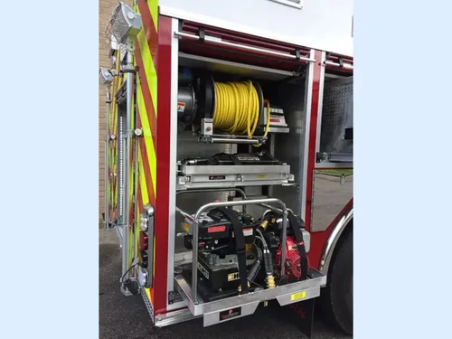 Exterior view of small fire truck showing cab, body compartments, and wheel/tire area.