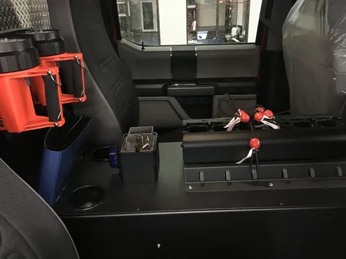 Exterior view of small fire truck showing cab, body compartments, and wheel/tire area.