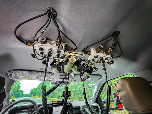 Overhead mounted electronics and wiring cluster above windshield.