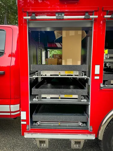 Open side compartment with slide-out tray and boxed items.