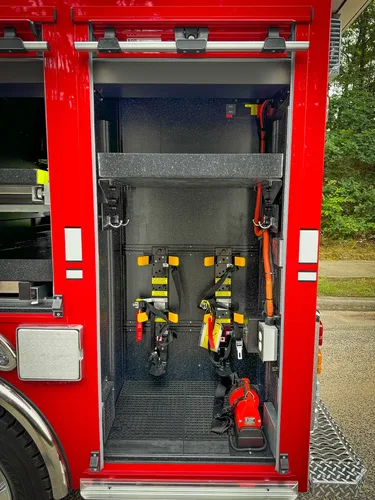 Narrow vertical side compartment with mounted yellow-handled tools.