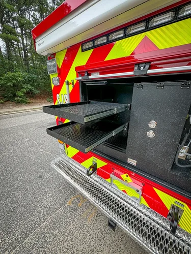 Rear compartment with lower slide-out tray extended and equipment bay exposed.