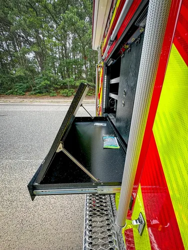 Narrow vertical rear-side bay showing interior wall and mounted hardware.