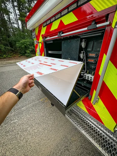 Rear fold-down panel close-up with white board section partially raised.