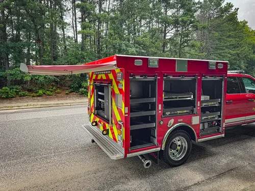 Rear-right three-quarter view with multiple compartment doors open.