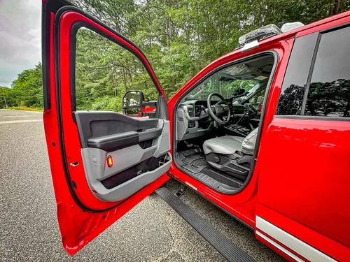 Open driver door view showing front seat and steering area.