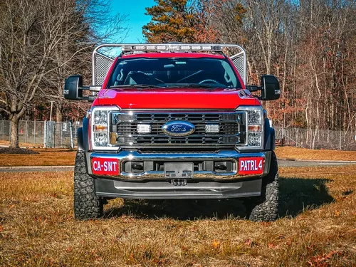 Head-on front view with grille, bumper, and warning lights.
