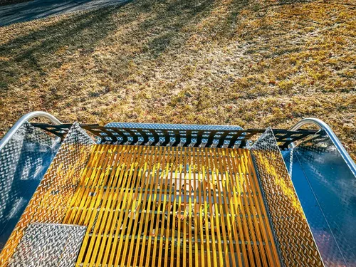 Top deck view down yellow grated walkway toward rear equipment area.