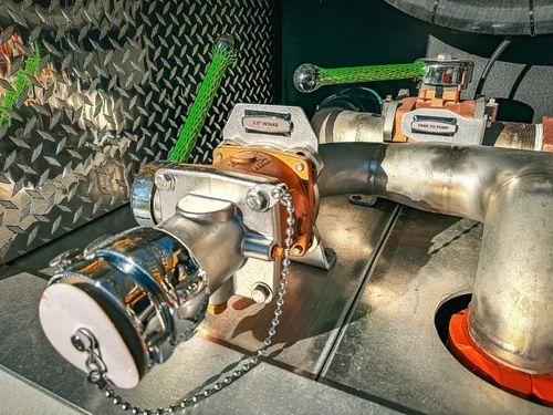 Close-up of large valve body and connected metal piping.