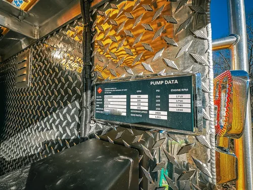 Rear corner close-up with pump data placard and diamond-plate wall.
