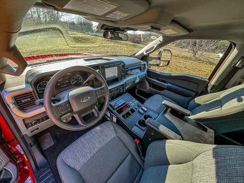 Front cabin interior view with steering wheel and center console.