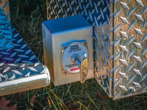 Exterior side panel close-up with electrical inlet and diamond-plate trim.