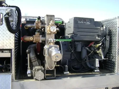 Exterior view of small fire truck showing cab, body compartments, and wheel/tire area.