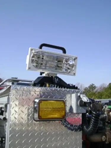 Exterior view of small fire truck showing cab, body compartments, and wheel/tire area.