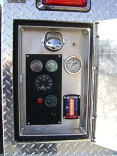 Exterior view of small fire truck showing cab, body compartments, and wheel/tire area.