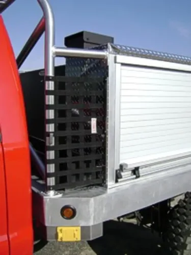 Exterior view of small fire truck showing cab, body compartments, and wheel/tire area.