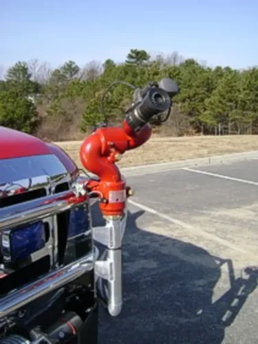 Exterior view of small fire truck showing cab, body compartments, and wheel/tire area.