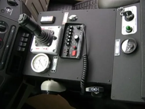 Exterior view of small fire truck showing cab, body compartments, and wheel/tire area.