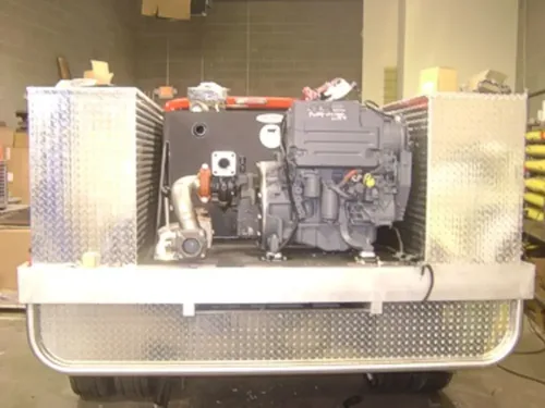 Exterior view of small fire truck showing cab, body compartments, and wheel/tire area.