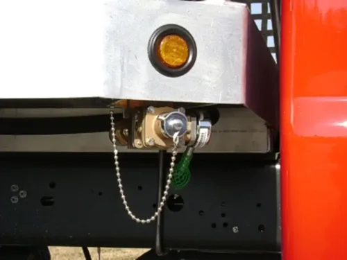 Exterior view of small fire truck showing cab, body compartments, and wheel/tire area.