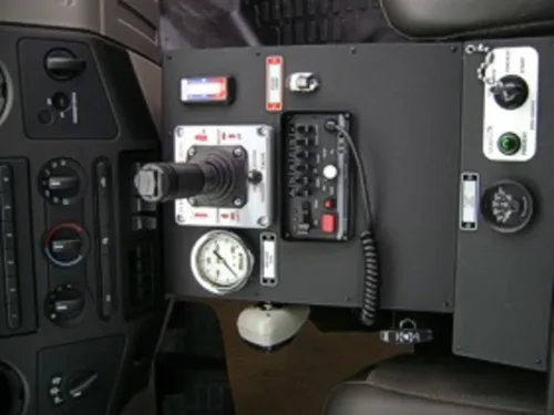 Exterior view of small fire truck showing cab, body compartments, and wheel/tire area.