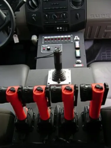 Exterior view of small fire truck showing cab, body compartments, and wheel/tire area.