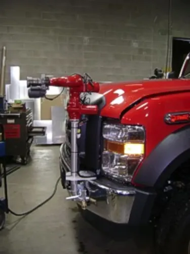 Exterior view of small fire truck showing cab, body compartments, and wheel/tire area.
