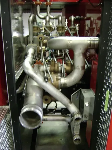 Exterior view of small fire truck showing cab, body compartments, and wheel/tire area.