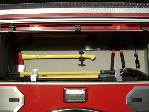 Exterior view of small fire truck showing cab, body compartments, and wheel/tire area.