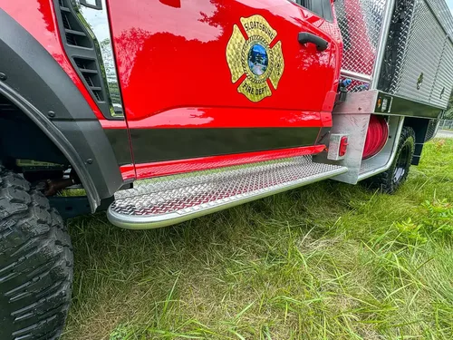 Side step and lower cab trim close-up beneath door emblem.