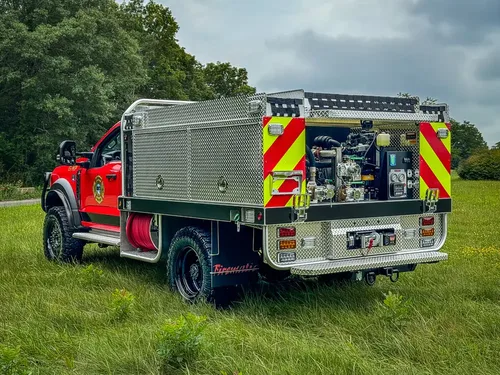 Rear-left three-quarter view with pump controls and rear step platform.