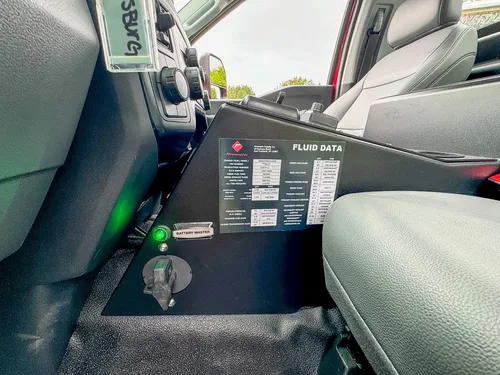 Passenger-side interior side panel with fluid data label and key switch.