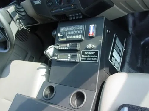 Exterior view of small fire truck showing cab, body compartments, and wheel/tire area.
