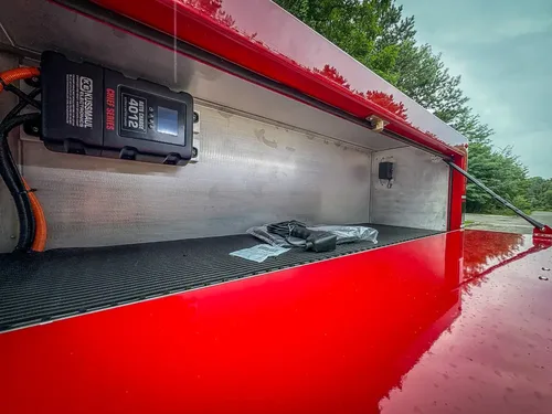 Top-side compartment close-up with mounted charger and cable routing.