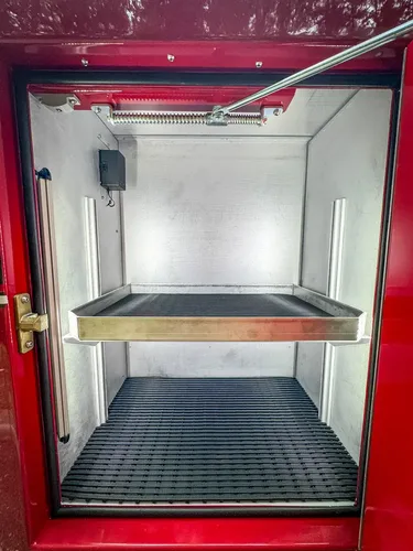 Open side compartment close-up with shelf and empty lower bay.