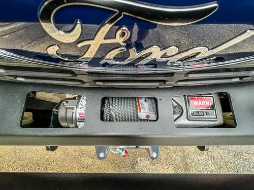 Front grille and bumper close-up with winch and license area.