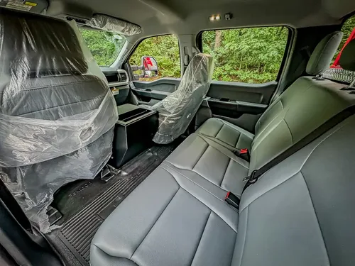 Rear seating area with protective plastic on front and rear seats.