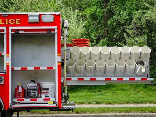 Exterior view of small fire truck showing cab, body compartments, and wheel/tire area.