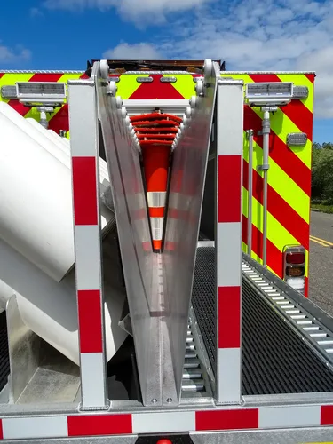 Exterior view of small fire truck showing cab, body compartments, and wheel/tire area.