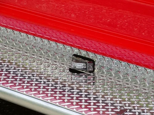 Exterior view of small fire truck showing cab, body compartments, and wheel/tire area.