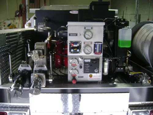 Exterior view of small fire truck showing cab, body compartments, and wheel/tire area.