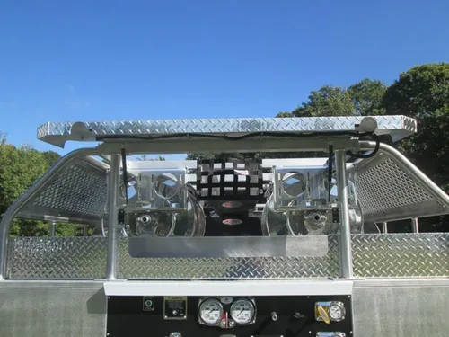 Exterior view of small fire truck showing cab, body compartments, and wheel/tire area.