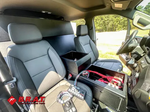 Exterior view of small fire truck showing cab, body compartments, and wheel/tire area.