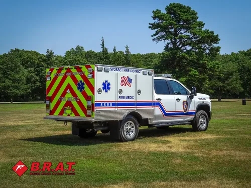 Exterior view of small fire truck showing cab, body compartments, and wheel/tire area.