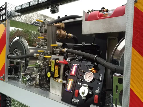 Exterior view of small fire truck showing cab, body compartments, and wheel/tire area.