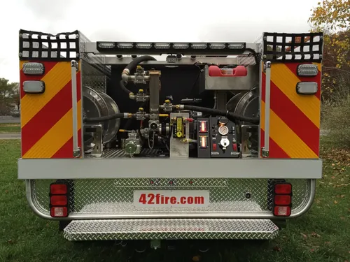 Exterior view of small fire truck showing cab, body compartments, and wheel/tire area.