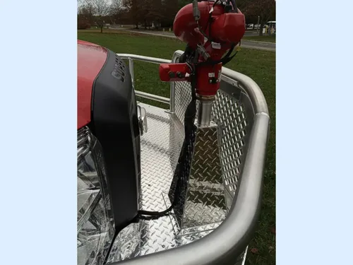 Exterior view of small fire truck showing cab, body compartments, and wheel/tire area.
