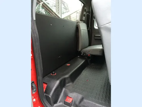 Exterior view of small fire truck showing cab, body compartments, and wheel/tire area.
