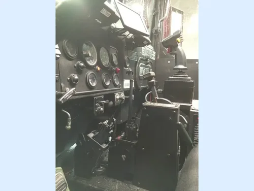Exterior view of small fire truck showing cab, body compartments, and wheel/tire area.